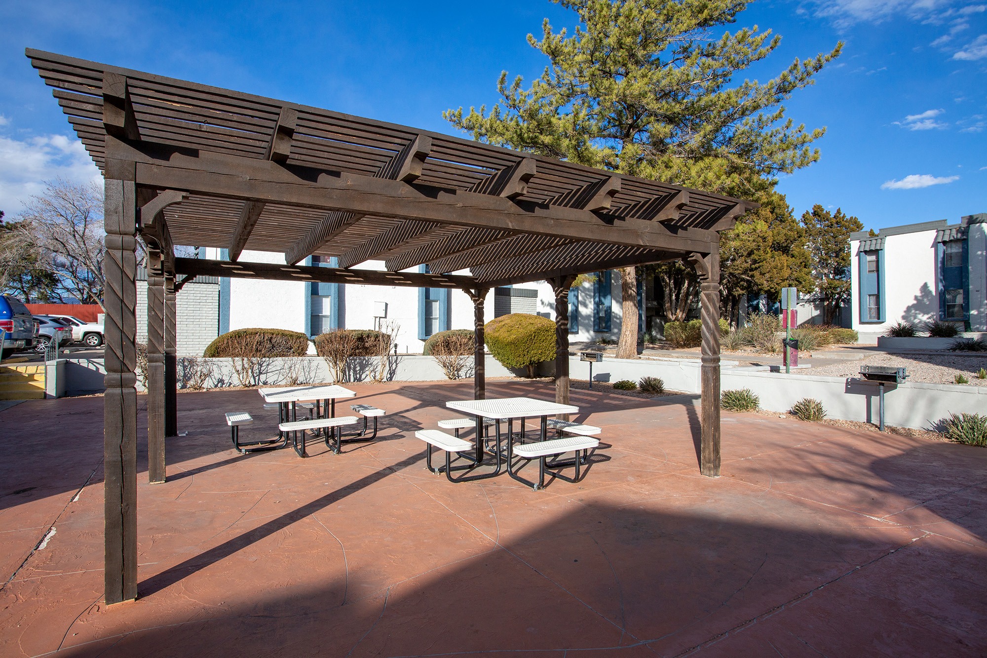 a picnic area with tables and benches in front of a building